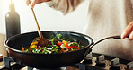 Spoon, cooking and hands of person in kitchen with food, health and wellness with traditional recipe for lunch. Diet, nutrition and chef with frying pan, vegetables and meal prep for dinner in home.