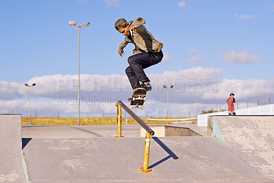 Buy stock photo Shot of a skateboarder performing a trick on a rail