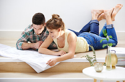 Buy stock photo New house, blueprints and couple on floor, planning and conversation for renovation. Happy people, apartment and man with woman, documents and property with cooperation, real estate and mortgage