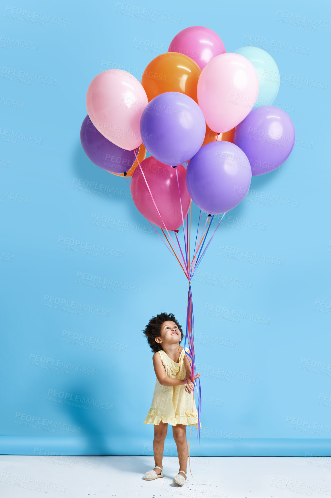 Buy stock photo Balloon, excited and child in studio for birthday, party and celebration with decoration. Playful, childhood and isolated young girl looking up for special day, surprise or present on blue background