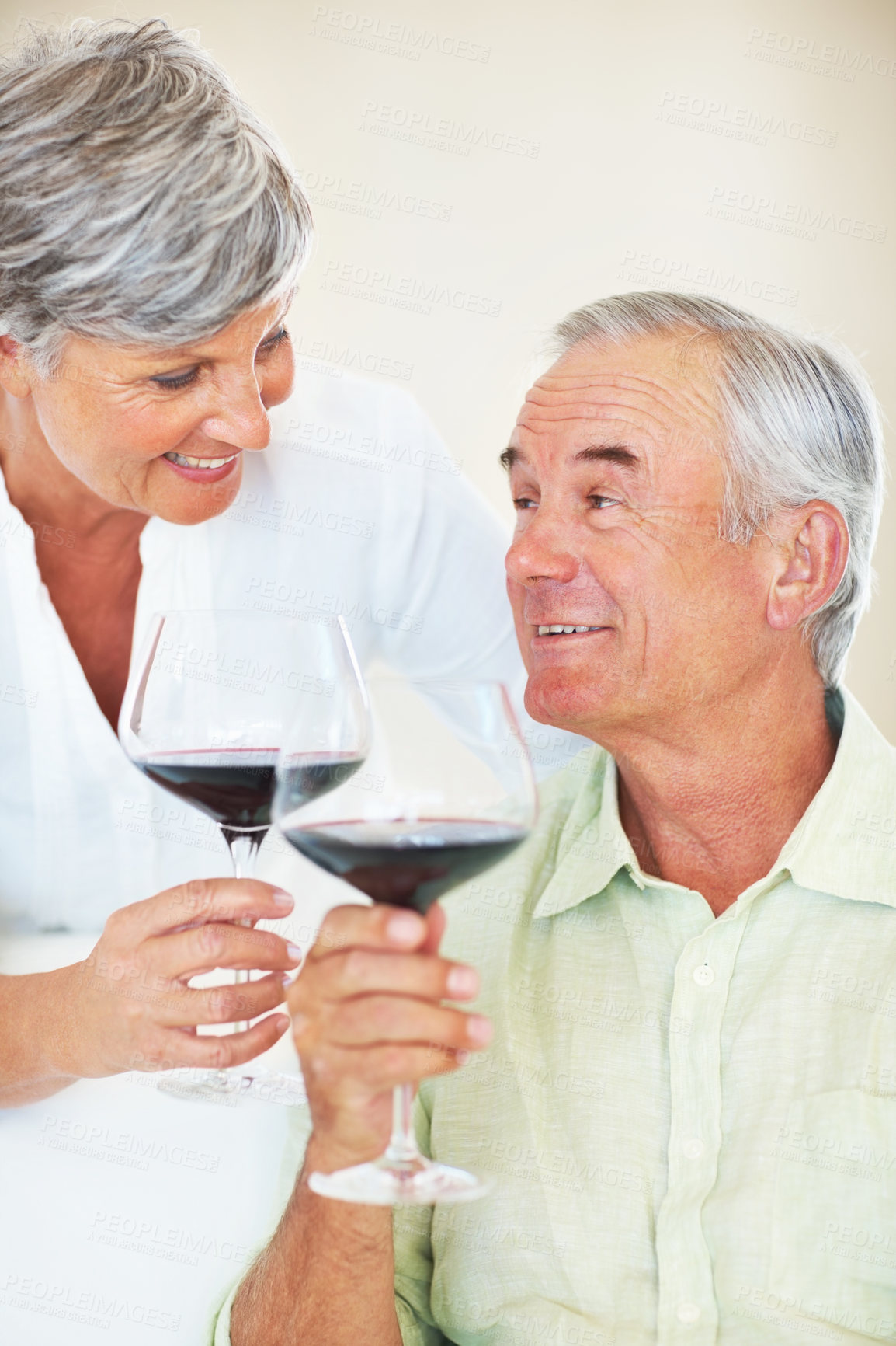 Buy stock photo Senior couple, wine and toast in home, marriage anniversary and growth in partnership. Elderly people, romance and cheers with alcohol glasses for love celebration, milestone and bonding on date