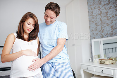 Buy stock photo Couple, smile and pregnant with stomach, touch and bonding in home for future motherhood support. People, happy and healthy pregnancy development for prenatal care, maternity and growth with relax