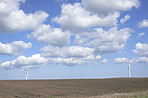 Clouds, landscape and sky with wind turbine for renewable energy outdoor to produce electricity. Earth, nature and recycling with windmill in nature environment for conservation or power supply