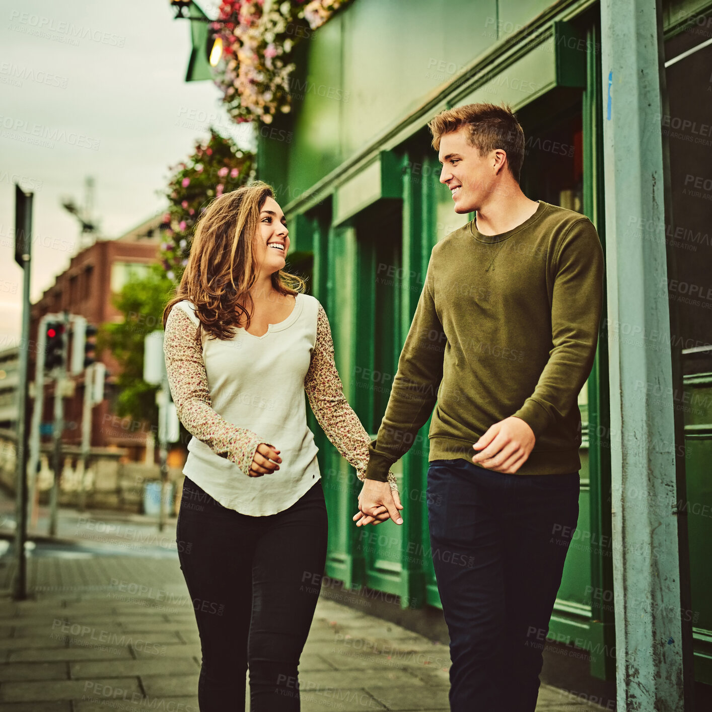 Buy stock photo Happy couple, walking and holding hands with love in city for support, romance or outdoor date together on sidewalk. Young man, woman or lovers with smile for romantic holiday or trip in Italy