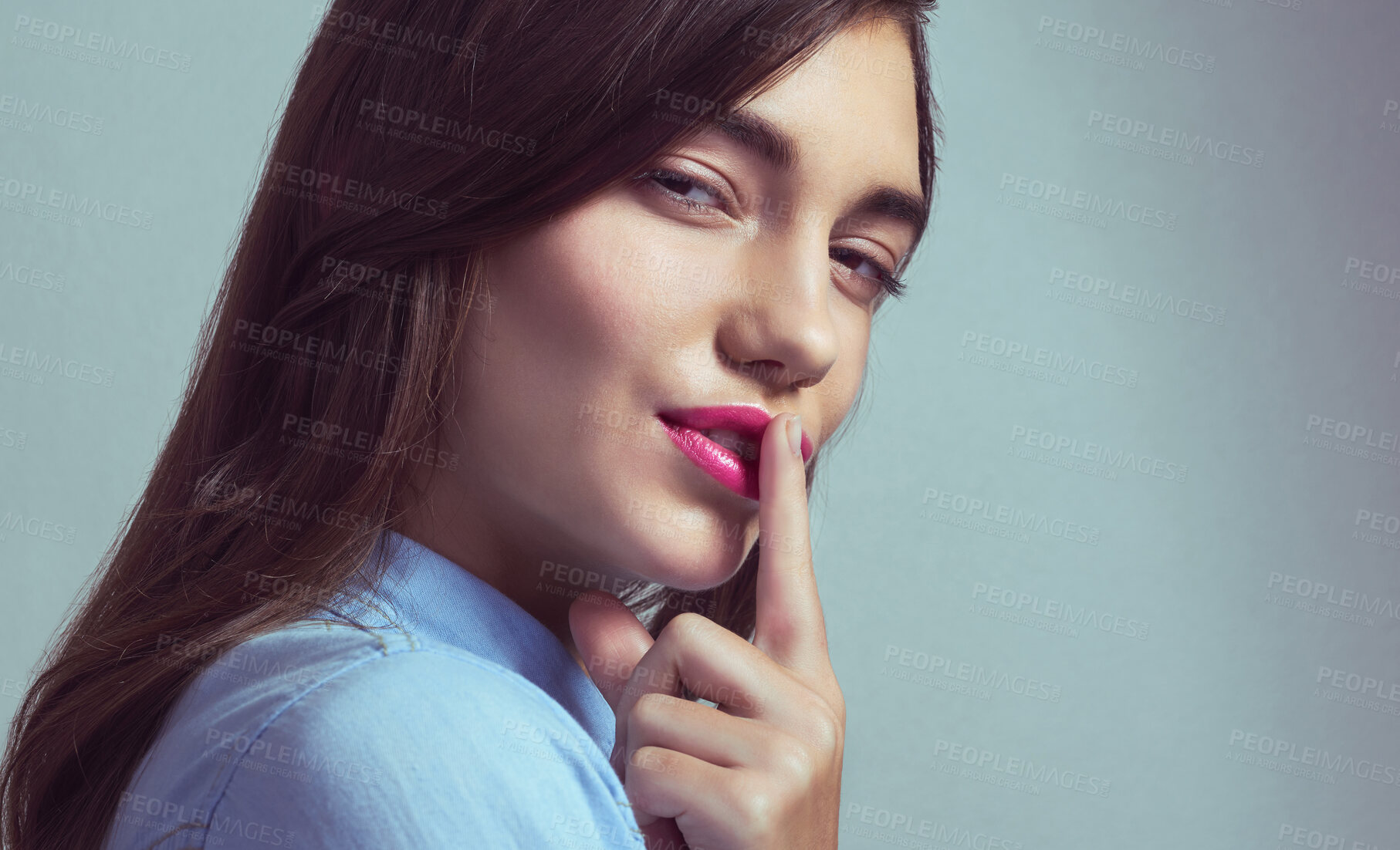 Buy stock photo Happy woman, portrait and finger with lips for secret, cosmetics or makeup on a studio background. Face, female person or attractive model with colorful lipstick, gossip or trick for beauty on space