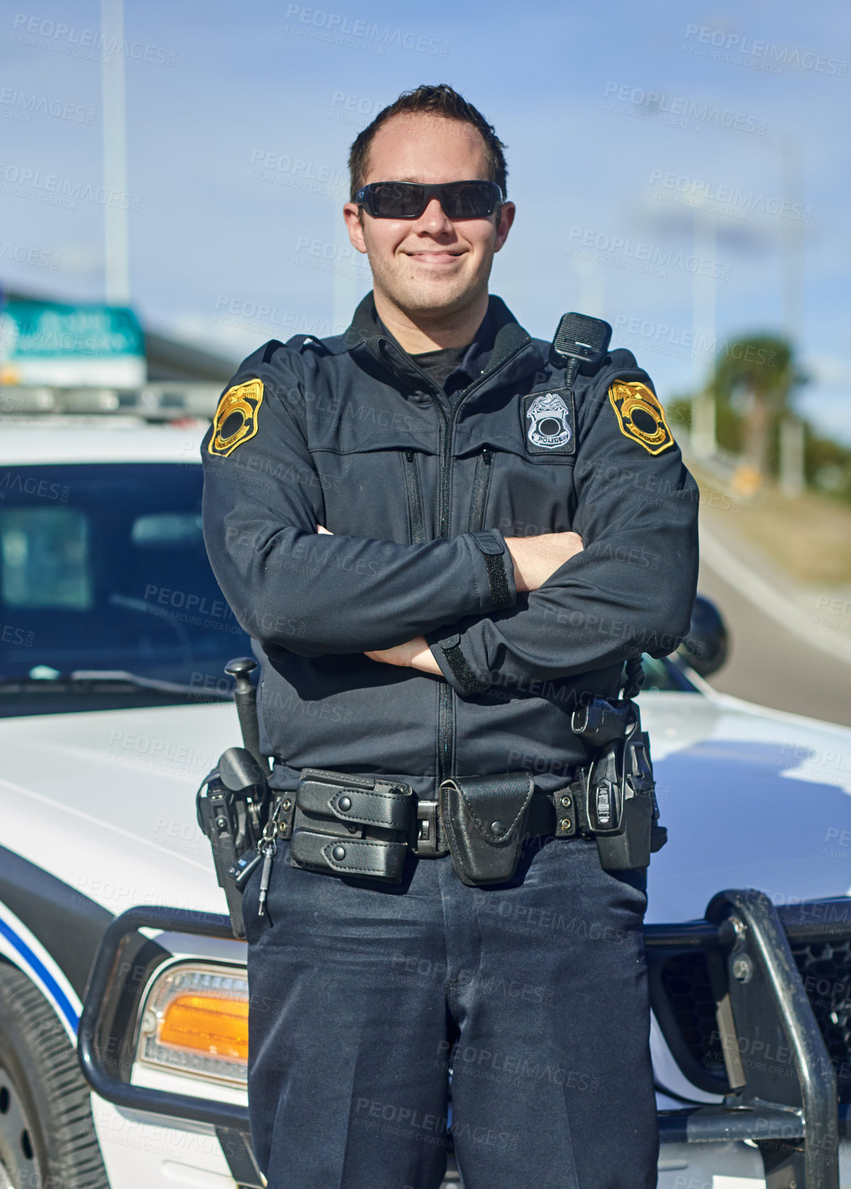 Buy stock photo Man, arms crossed and police officer on patrol, city and uniform for responsibility in town. Male person, law enforcement and cop for public service of security, sunglasses and authority in traffic