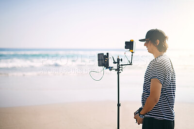 Buy stock photo Videographer, man and camera at sea for film, photography production and nature documentary. Cameraman, recording and shooting with equipment outdoor for filmmaking at beach, holiday and video mockup