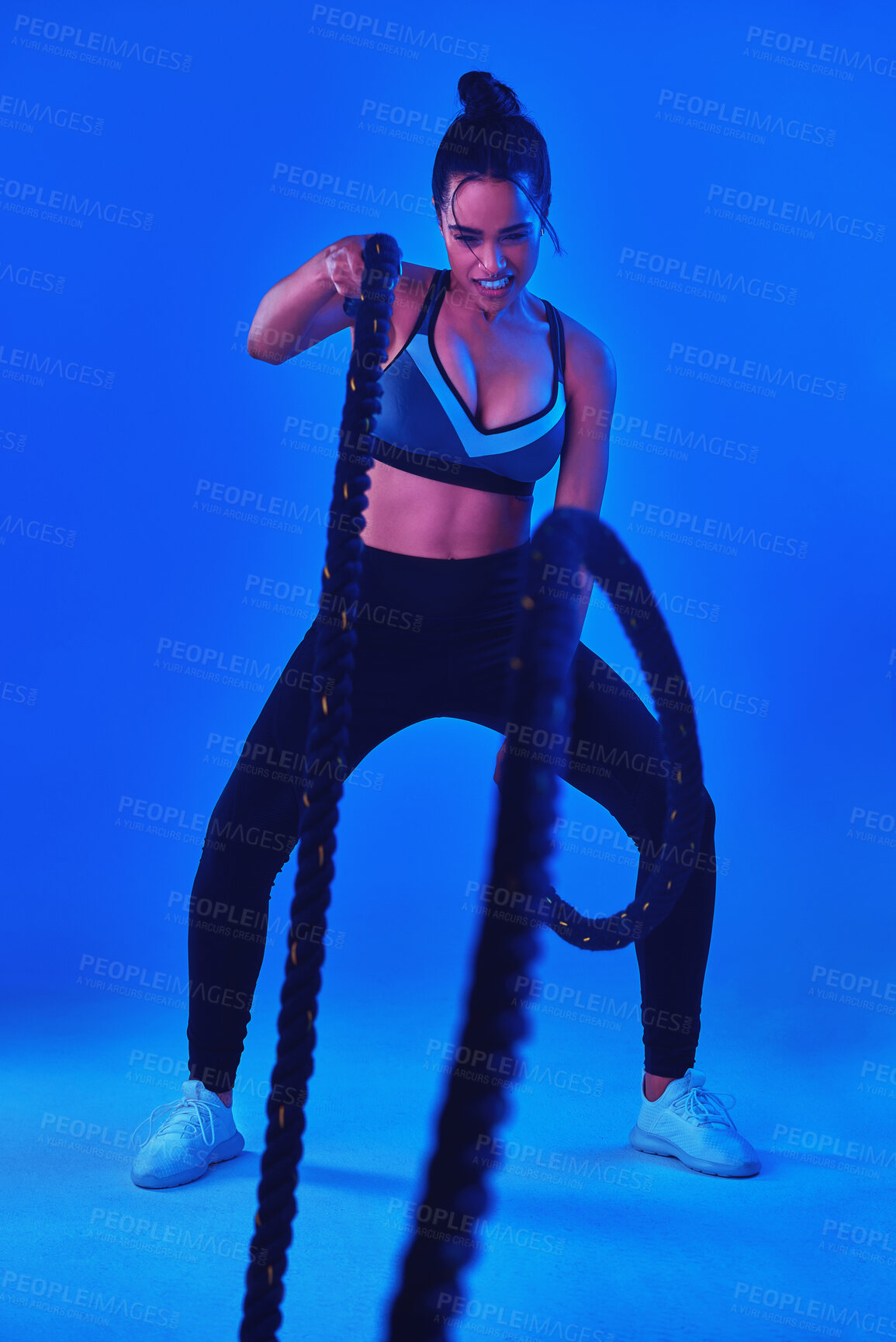 Buy stock photo Strong, battle rope and woman in studio for fitness, bodybuilder workout and exercise. Personal trainer, gym and person with equipment for health, wellness and muscle strength on blue background