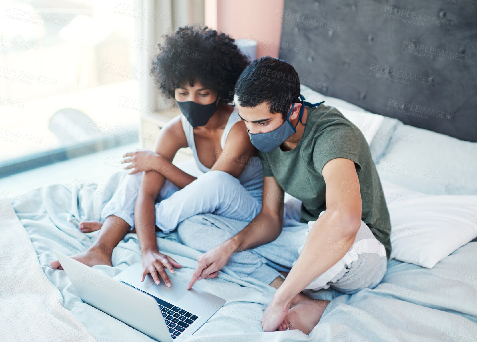 Buy stock photo Couple, mask and laptop on bed in home with quarantine together and symptoms research for mpox virus. Interracial people, germs prevention or technology in bedroom for streaming subscription in house