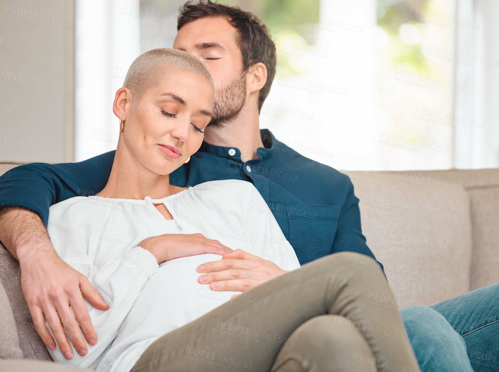 Buy stock photo Pregnancy, kiss and couple with love, house and bonding together with parents in lounge. Apartment, pregnant woman and happy man on sofa, care and wellness with maternity, relationship and stomach