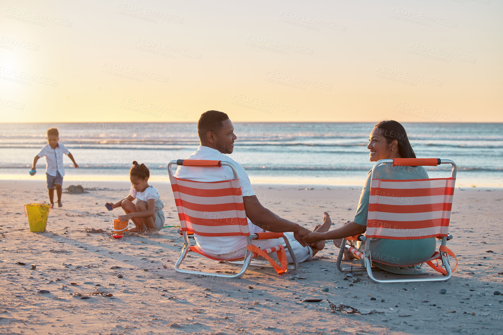 Buy stock photo Parents, chair or children at beach for sunset, holiday or travel on break with boy, girl or family. Playing, mom or father with kids at sea on vacation together for sandcastle or nature to relax