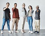 Group of five diverse happy businesspeople showing a thumbs up while standing in a meeting in an office at work. Businesspeople smiling and showing a thumbs up. Men and woman showing support together