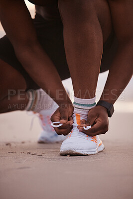 Buy stock photo Fitness, beach and hands of man with shoes for running, morning exercise and marathon training in nature. Sneakers, laces and runner on ocean sand getting ready for outdoor health workout at sunset