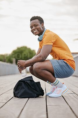 Buy stock photo Happy, fitness and portrait of black man in city for exercise, training and warm up for workout. Smile, sports and person with bag and water bottle in urban town for health, wellness and running