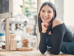 Portrait of one happy young hispanic waitress working in a store or cafe. Friendly woman and coffeeshop owner managing a successful restaurant startup