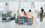 Group of diverse businesspeople having a meeting in a modern office at work. Young african american businesswoman doing a presentation of an idea on a whiteboard in a boardroom with colleagues. Businesspeople planning together