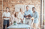 Group of diverse architects discussing plans, blueprints and schematics during a meeting in their office boardroom. Business people brainstorming and planning their upcoming project development