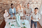 Group of diverse architects discussing plans, blueprints and schematics during a meeting in their office boardroom. Business people brainstorming and planning their upcoming project development