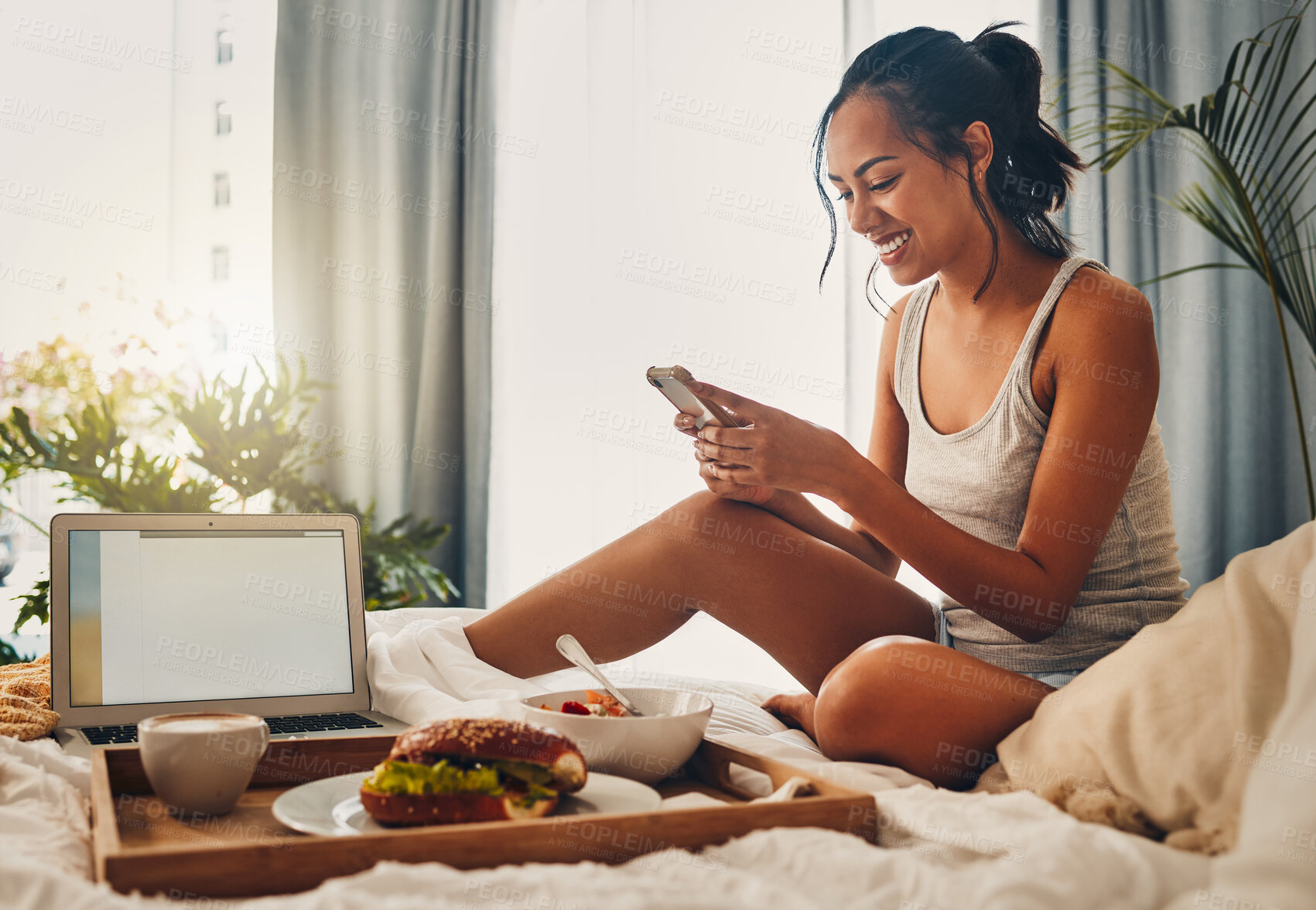 Buy stock photo Breakfast, smile and woman with phone in bedroom for social media, typing message and morning food. Mobile, girl and scroll in bed for relax, reading blog and mockup space on laptop screen in home