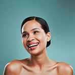 A young beautiful mixed race woman with smooth soft skin posing and smiling against a green studio background. Attractive Hispanic female with stylish makeup posing in studio