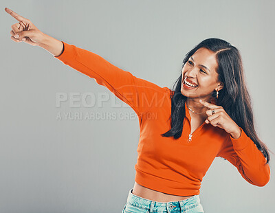 Buy stock photo Happy, woman and pointing for direction in studio with announcement, competition giveaway and retail sale. Smile, girl and show sign for advertising, coming soon and promotion vote on gray background