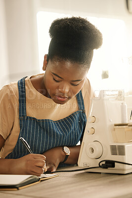 Buy stock photo Black woman, fashion student and writing on journal with sewing machine at creative academy. Female person, gen z and seamstress or tailor for education, learning and project with talent and skill