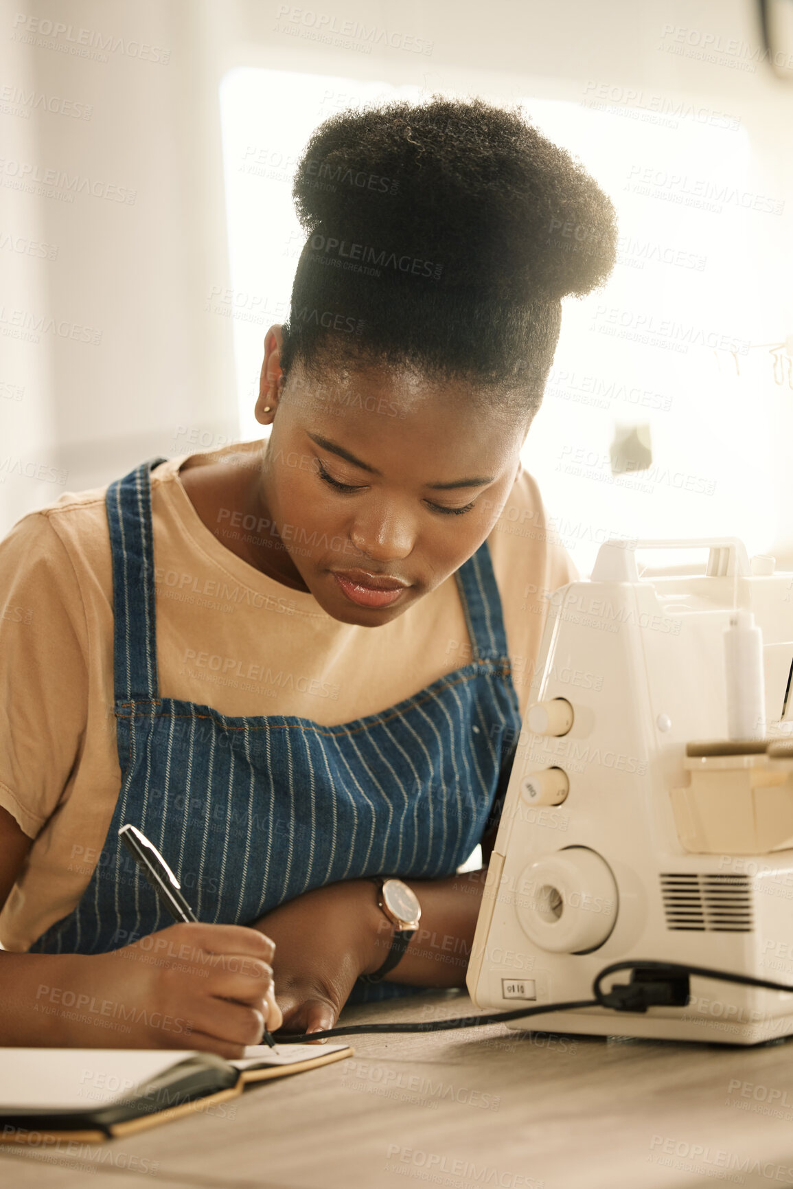 Buy stock photo Black woman, fashion student and writing on journal with sewing machine at creative academy. Female person, gen z and seamstress or tailor for education, learning and project with talent and skill