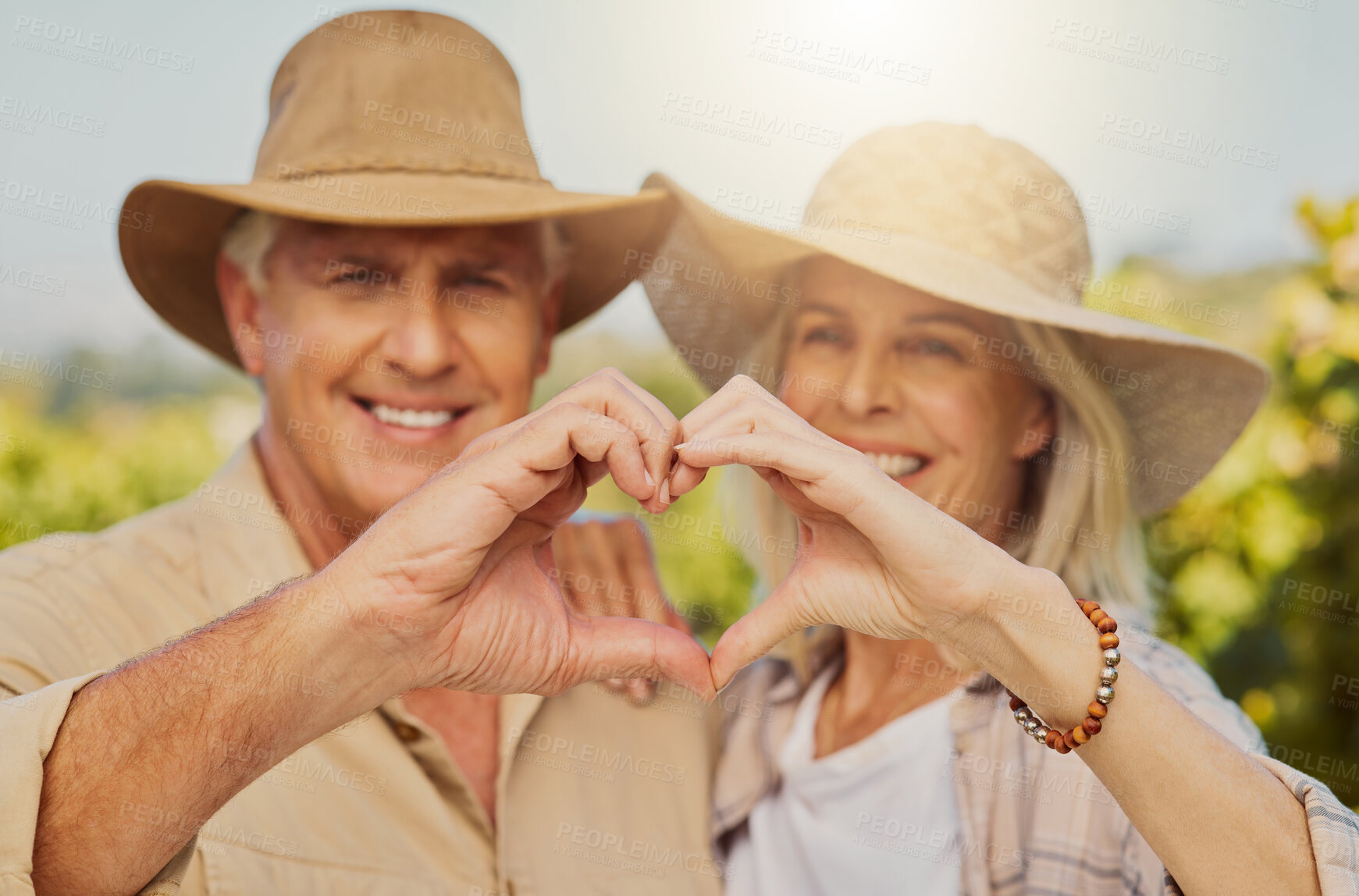 Buy stock photo Couple, portrait and love sign by nature for relationship, holiday and bonding together on date with hug. Mature, people and heart on countryside farm for romance, vacation and embrace with sunshine