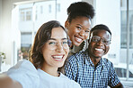 Portrait of a group of young cheerful businesspeople taking a selfie together at work. Happy hispanic businesswoman taking a photo with her colleagues in an office