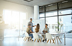 Group of diverse businesspeople having a meeting in an office at work. Young african american businessman talking while doing a presentation for colleagues