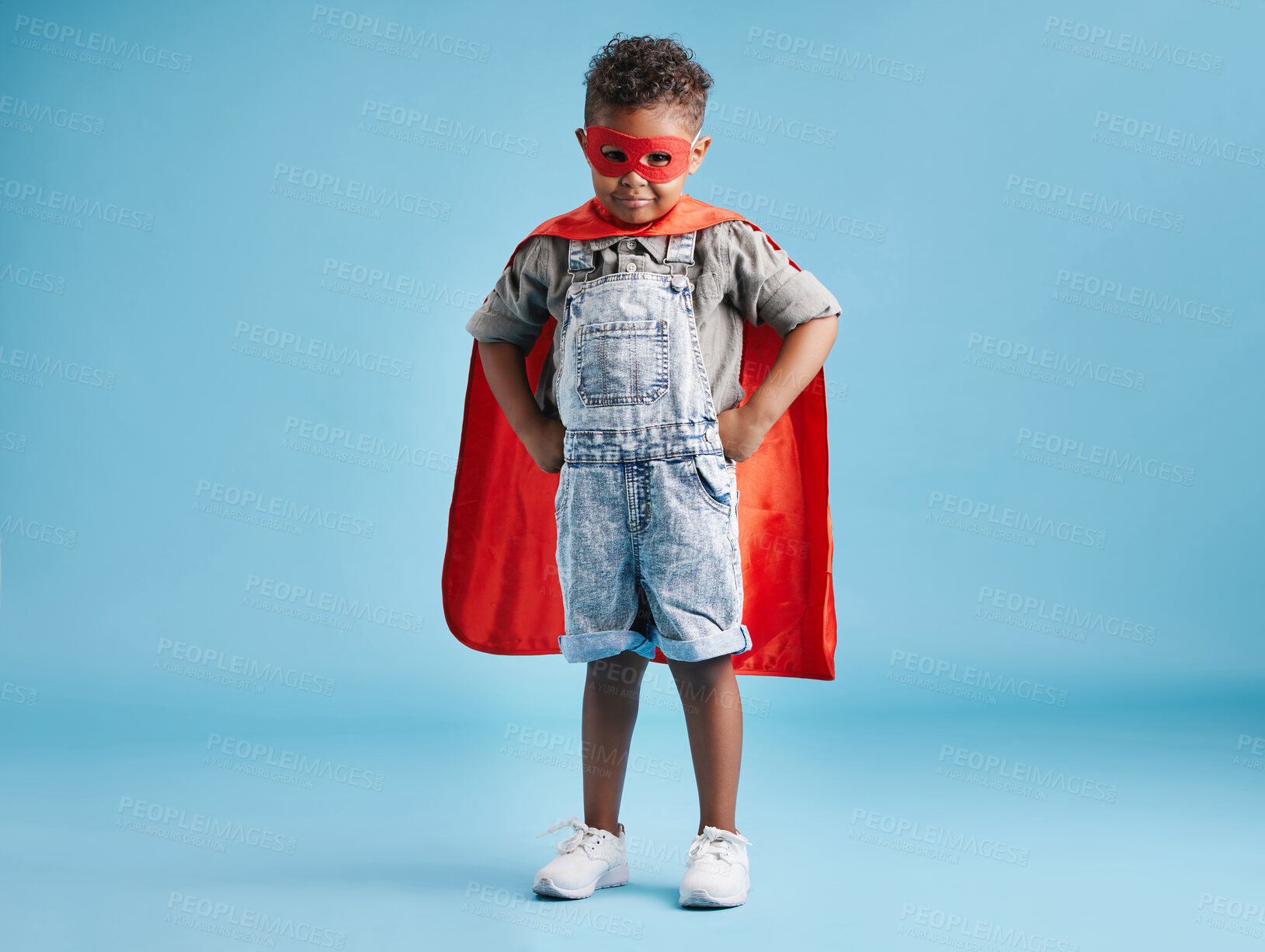 Buy stock photo Boy, child and superhero with mask in studio portrait for fantasy, playful and confident by blue background. Kid, cape and pride for action, character and power for halloween party in Costa Rica