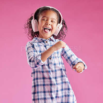 Buy stock photo Girl, child and dancing with headphones in studio with singing, excited and karaoke by pink background. Kid, happy and listening to music with streaming subscription, sound and smile with audio tech