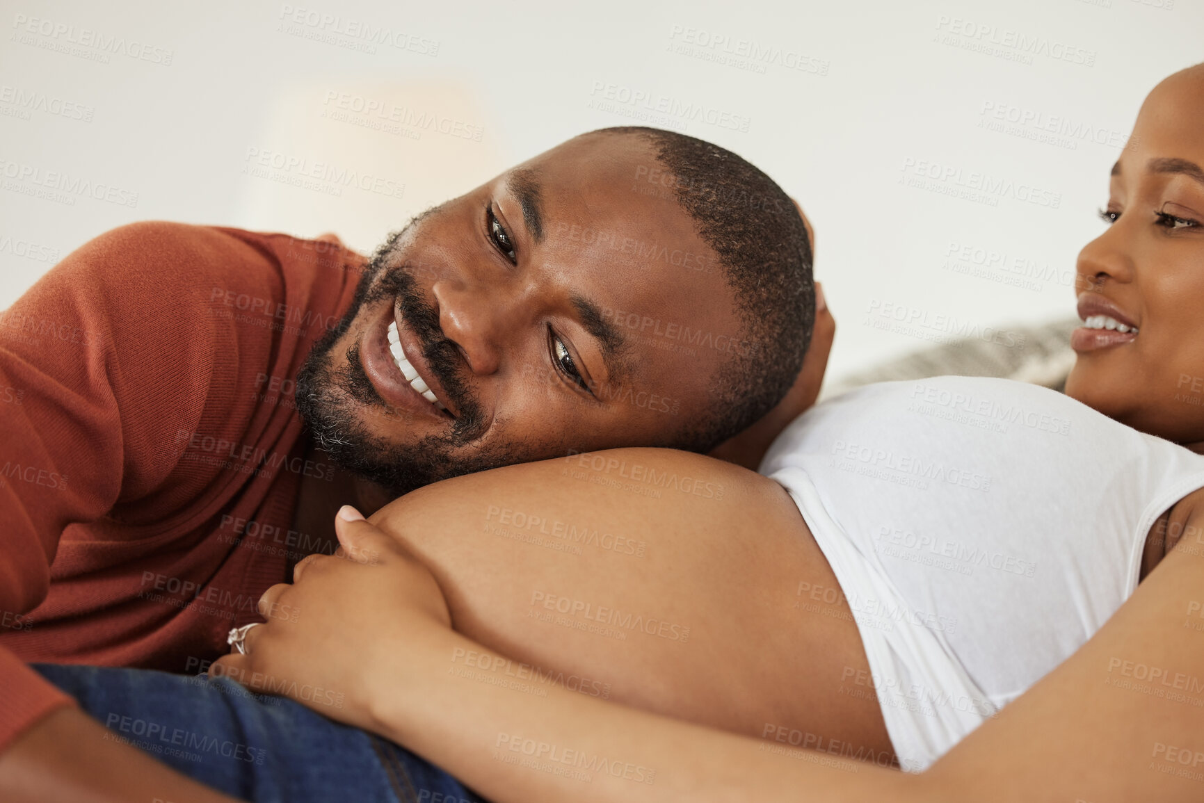 Buy stock photo Black man, pregnant woman and listen to stomach in bedroom with smile, excited and bonding in home. Couple, parents and happy with belly, baby and kicking with connection in morning at apartment