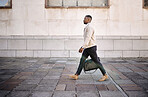 Black businessman travelling alone.A african american businessman walking around town with his luggage while looking stylish in the city
