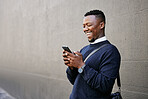 Businessman using his cellphone while walking in the city. Man using cellphone while commuting to work. Using internet while walking outside. Man using internet while commuting