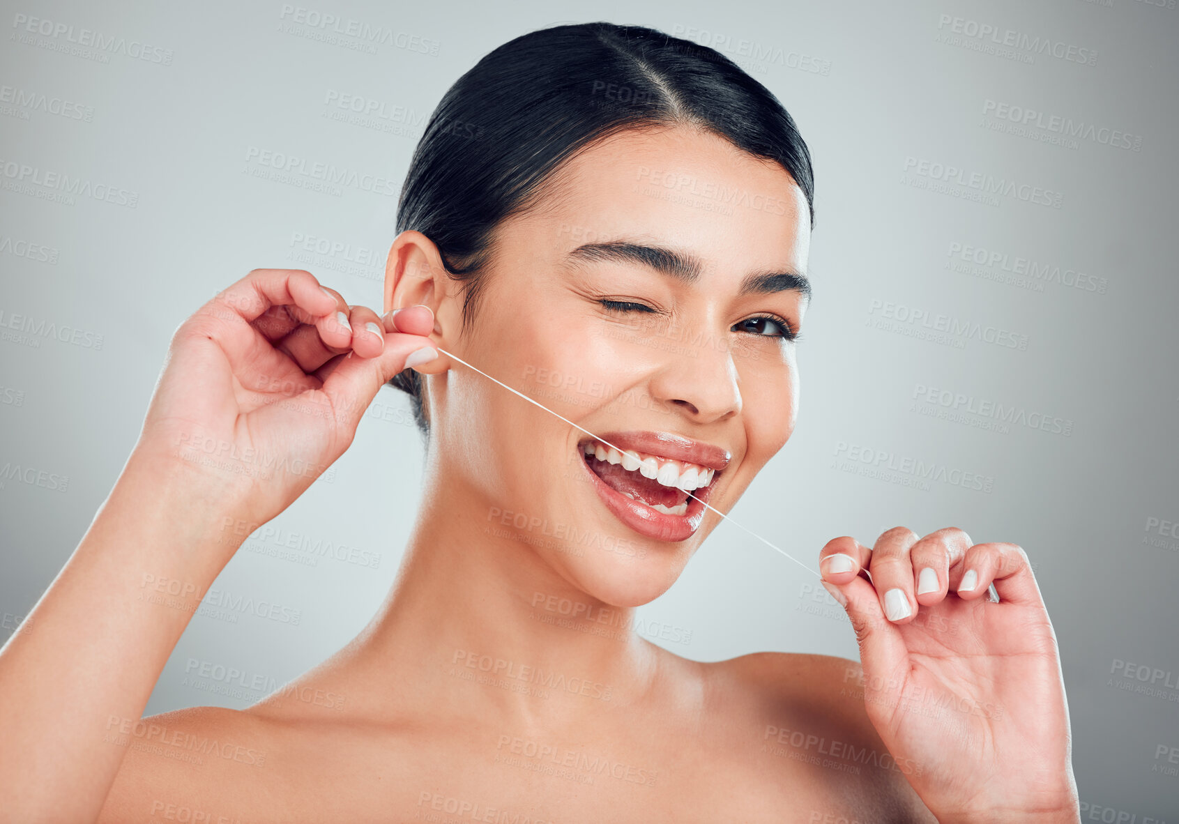 Buy stock photo Wink, plaque or portrait of woman flossing teeth for mouth, oral hygiene and tooth care in studio. Gum, fresh breath and happy female model with dental floss, thread or wellness on white background