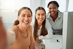 Portrait of a confident young hispanic business woman taking selfies with her colleagues in an office. Group of three happy smiling women taking photos as a dedicated and ambitious team in a creative startup agency