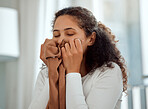 Young woman cleaning laundry at home. Young woman smelling fresh laundry at home. Content woman relaxing at home. Woman holding a cleaned item of clothing. Comfy woman smelling the scent of washing