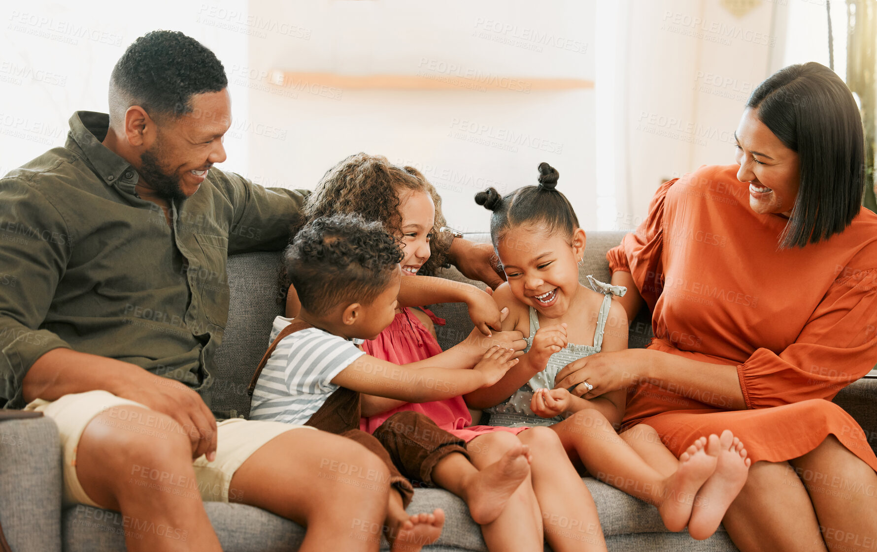 Buy stock photo Funny, tickle and care with family on sofa for love, playful game and happiness together. Bonding, energy and laughing with parents and children in living room at home for silly, comedy and joke