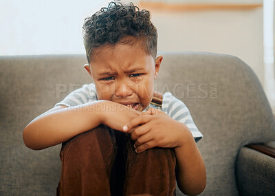 Buy stock photo Crying, sad and portrait of child on sofa with tears for bad behavior, naughty and conflict in home. Family, youth and young boy on couch with unhappy, sorrow and hurt emotions in living room