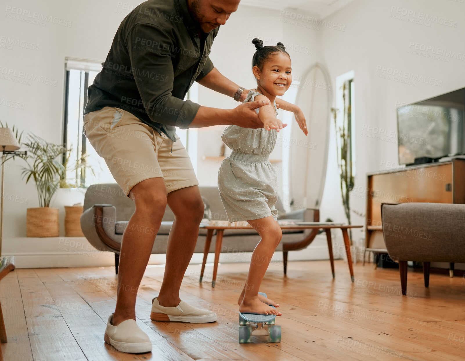 Buy stock photo Home learning and dad with girl with skateboard for bonding, relationship and fun together. Family, happy and father with young girl skating for balance, skills and help on weekend in living room