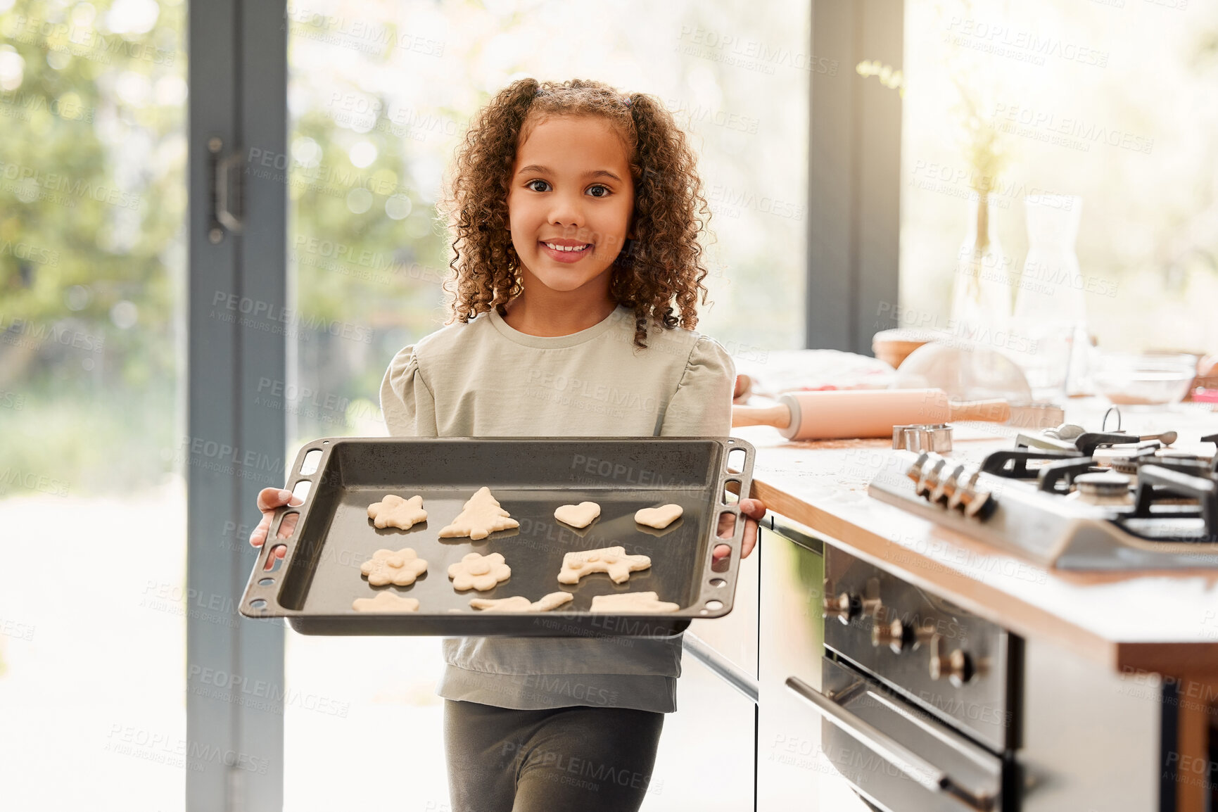 Buy stock photo Girl, child and tray for baking cookies in portrait for Christmas celebration with smile in family home. Kid, cooking and biscuit with snack, food and festive dessert for xmas at house in Costa Rica