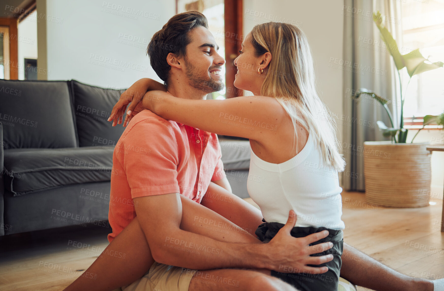 Buy stock photo Love, hug and happy couple relax on floor in home for care, bonding together or communication with partner. Living room, man and woman embrace for romantic relationship, support and trust for loyalty