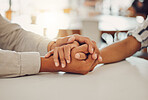 Close up of young man and woman holding hands at wooden table, from above. Loving couple expressing empathy, understanding and trust in their relationship