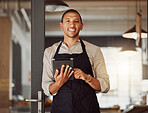 Portrait of businessman using a digital tablet. Mixed race business owner using a wireless digital device. Shop owner standing in entrance using an online app. businessman using a digital device