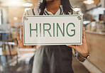 Hands of business owner holding hiring sign. Businesswoman hanging hiring sign in cafe entrance. Boss advertising that hr is hiring staff. Small business owner hanging message in shop door