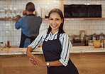 Barista in her cafe kitchen. Business owner working in her coffeeshop with her partner. Colleagues together in their restaurant. Portrait of a boss in her retail store with her partner