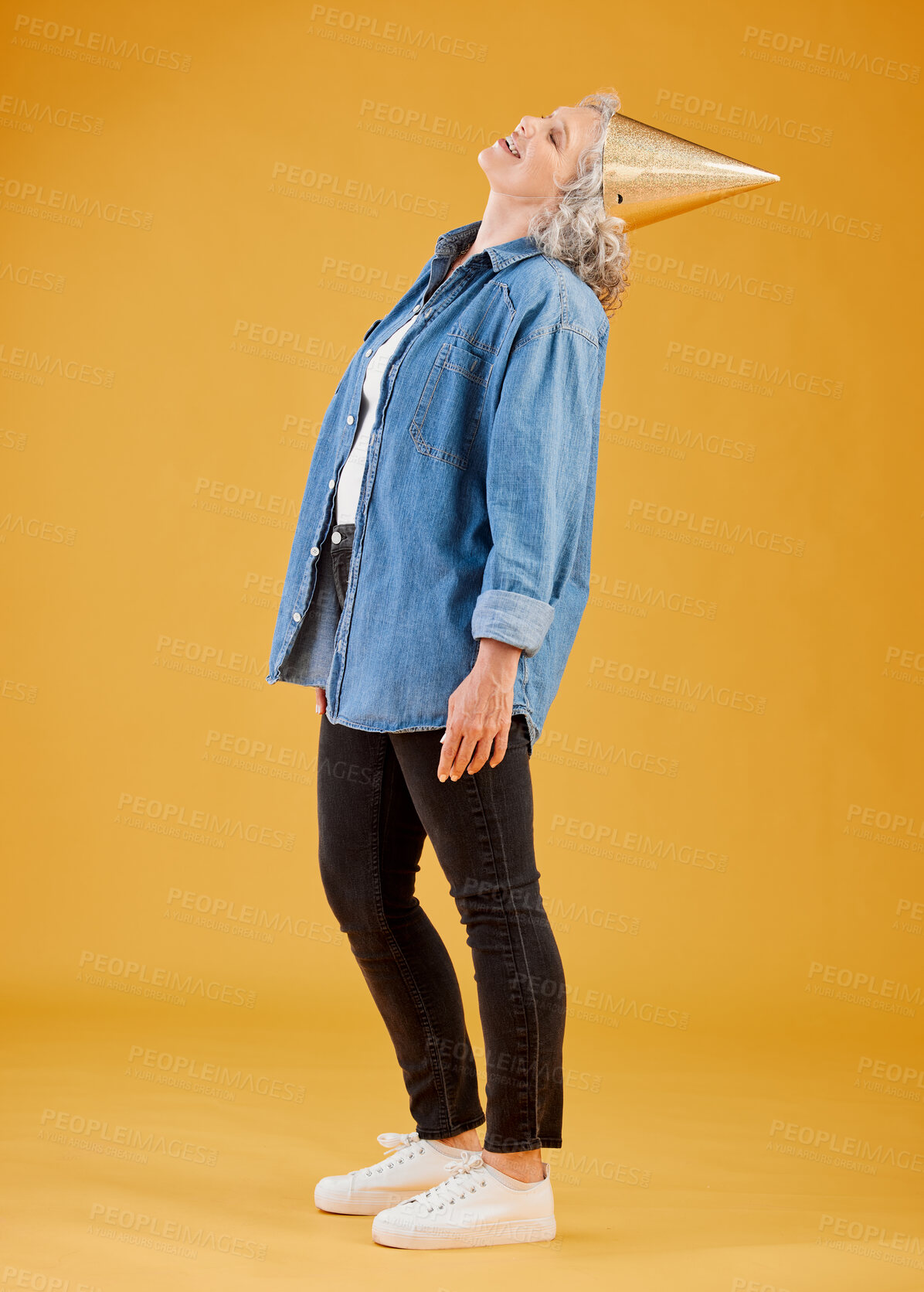 Buy stock photo Birthday, party hat and smile with mature woman in studio isolated on yellow background for celebration. Event, milestone and retirement with happy senior person in casual outfit for carnival or gala