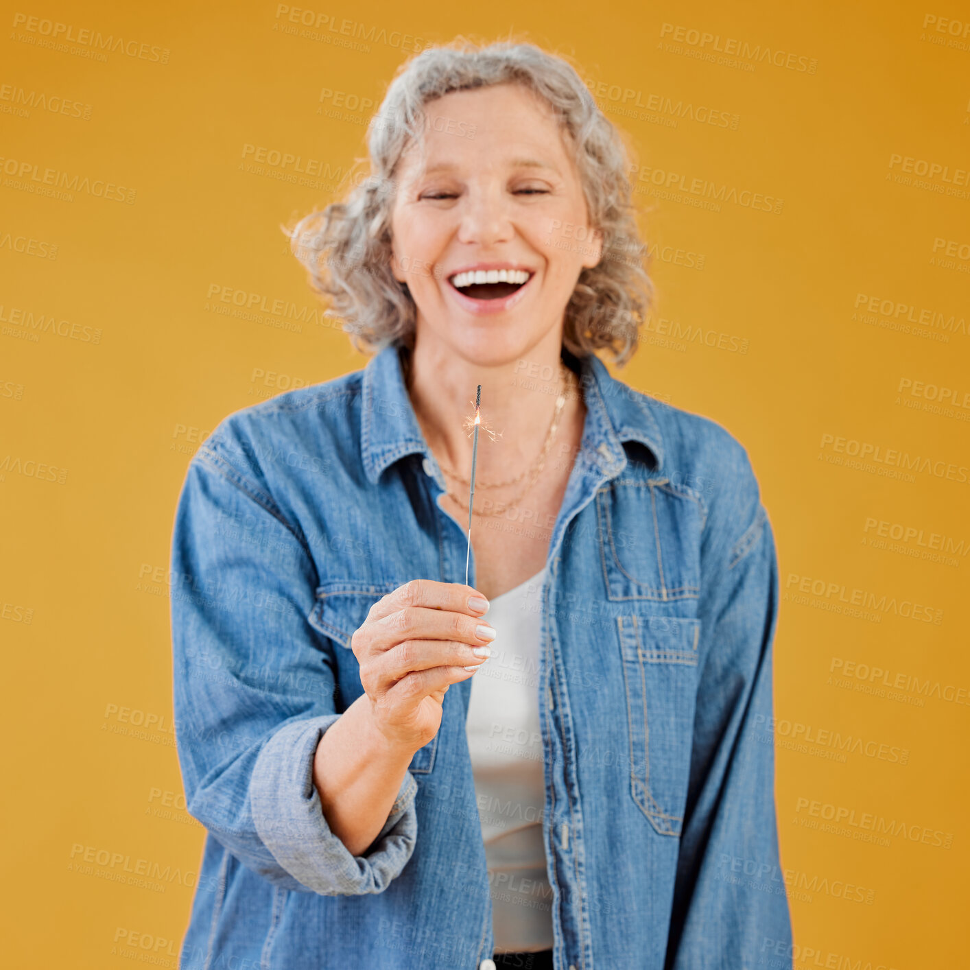 Buy stock photo Senior, woman and sparkler for celebration in studio with birthday party, new year and holiday event. Fireworks, mature person and laughing on mockup space with fire lights fun on yellow background