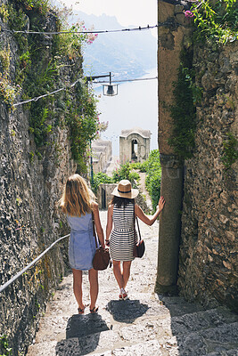 Buy stock photo Women, friends and back on stairs on vacation by ocean for tourism, adventure and walk in town. People, outdoor and steps in village by alley on holiday for view of sea, mountains and spring in Italy